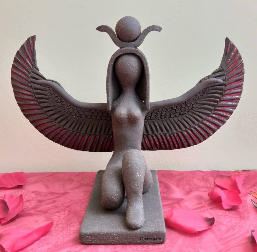 Diosa alada de cerámica modelada a mano, con las alas abiertas y disco solar