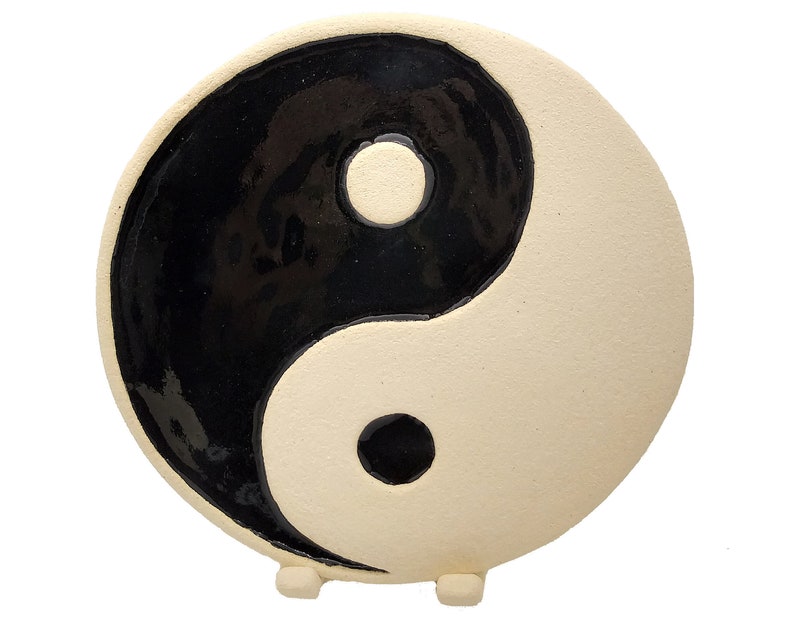 Símbolo yin yang de cerámica sobre un soporte de tres patas