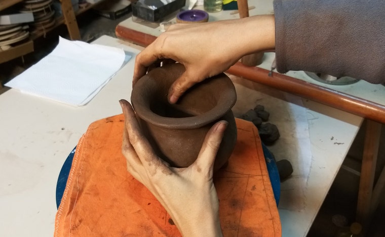 Las manos modelando una pieza de barro en el taller de Terrakuita